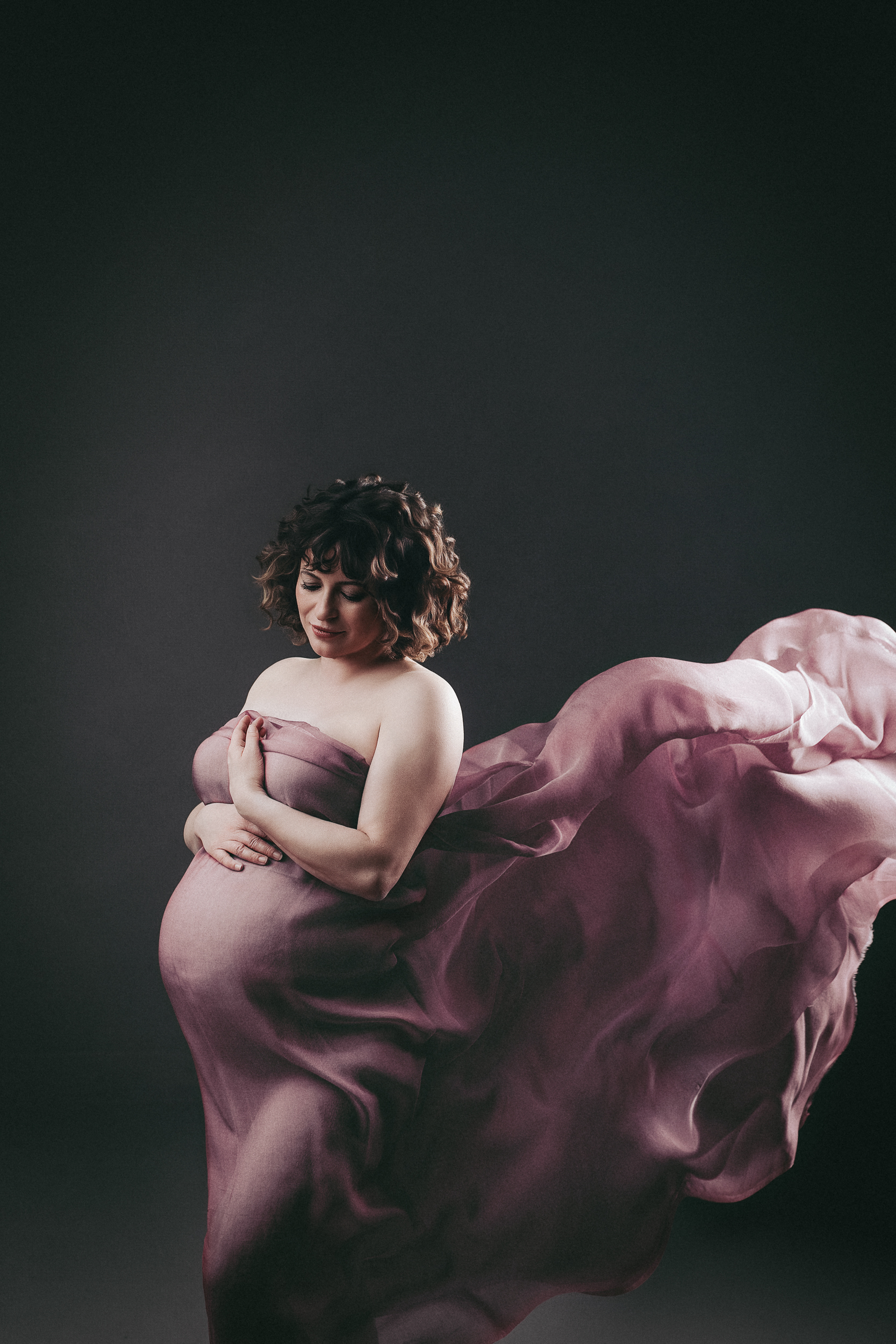 Pregnant woman in flowing pink fabric.