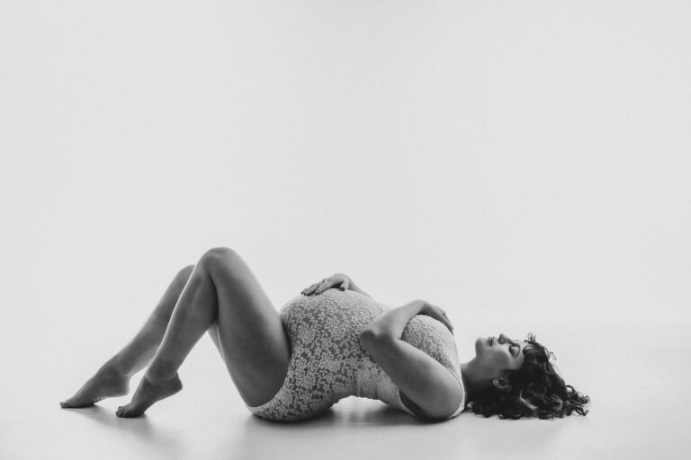 Classic maternity portrait with elegant styling and timeless photography setup in black and white