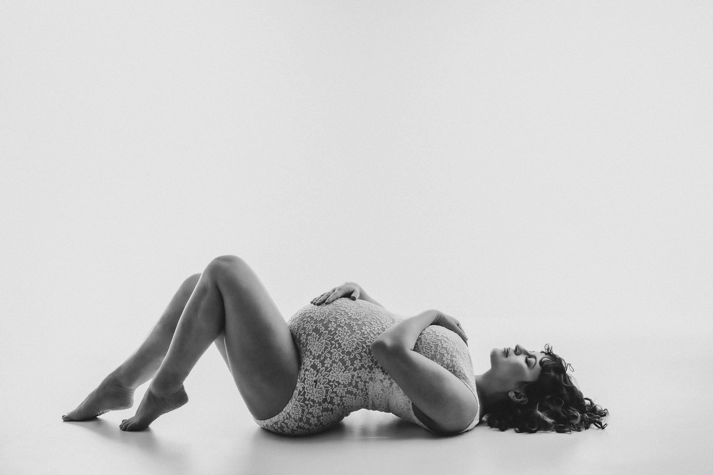 Classic maternity portrait with elegant styling and timeless photography setup in black and white
