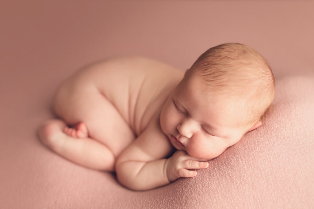 Sleeping newborn baby on pink backdrop by Jana Photography Burnaby BC