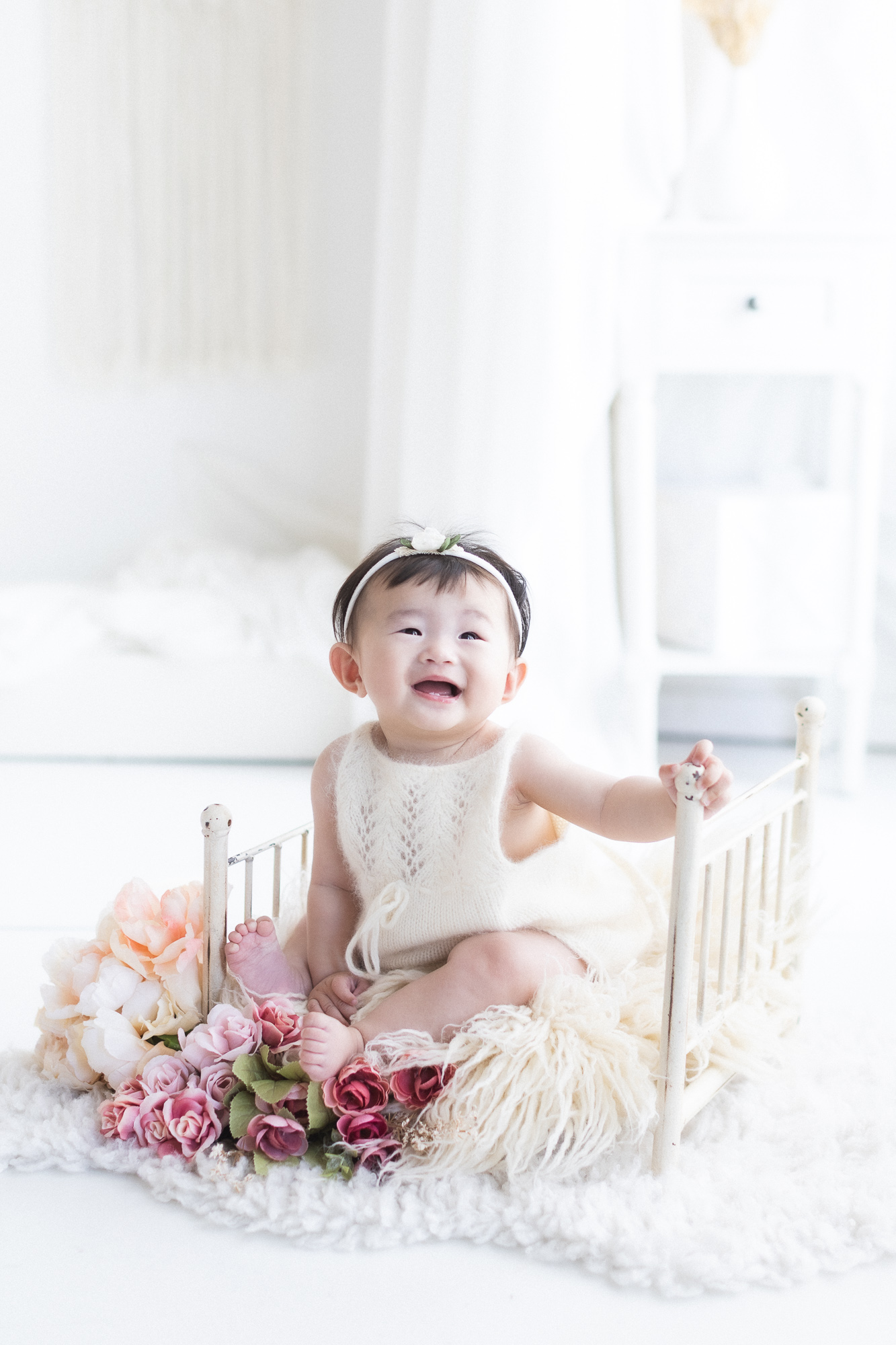 Baby sitting up with floral props during a Vancouver sitter session