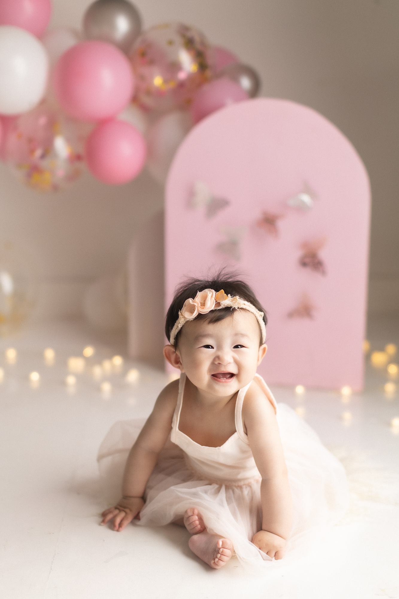 Studio setup for a baby sitter session in Vancouver with pink balloon backdrop