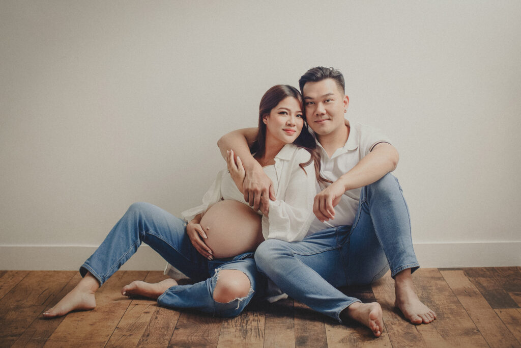 Pregnant couple embracing during a casual studio maternity photography session in Vancouver